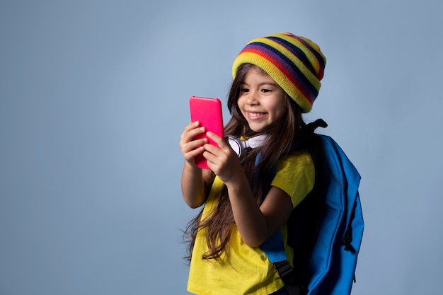 Niña de la escuela asiática comprobando su teléfono