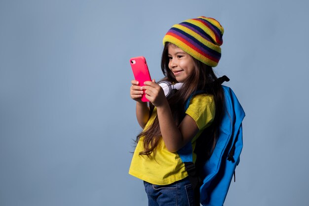 Niña de la escuela asiática comprobando su teléfono