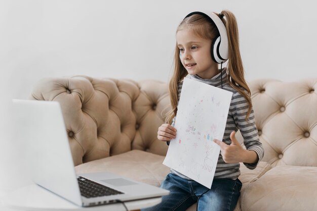 Niña de la escuela con auriculares cursos virtuales