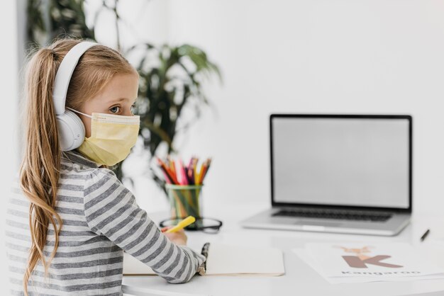 Niña de la escuela con auriculares escuela virtual