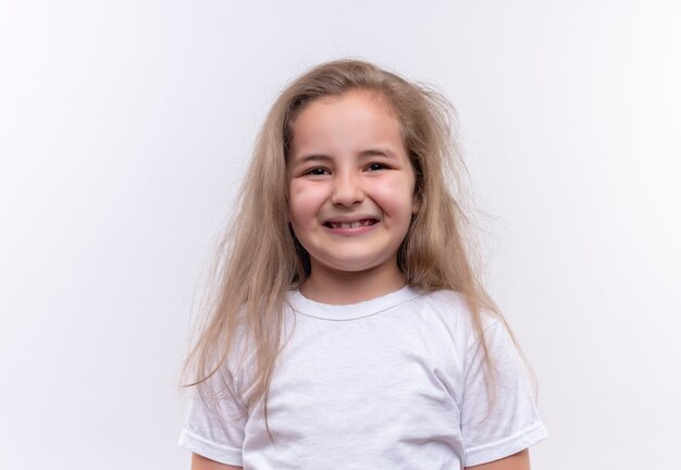 Niña de la escuela sonriente vistiendo camiseta blanca sobre fondo blanco aislado