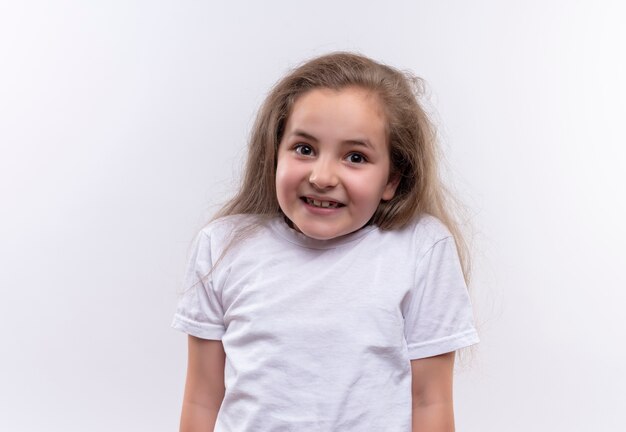 Niña de la escuela sonriente vistiendo camiseta blanca sobre fondo blanco aislado