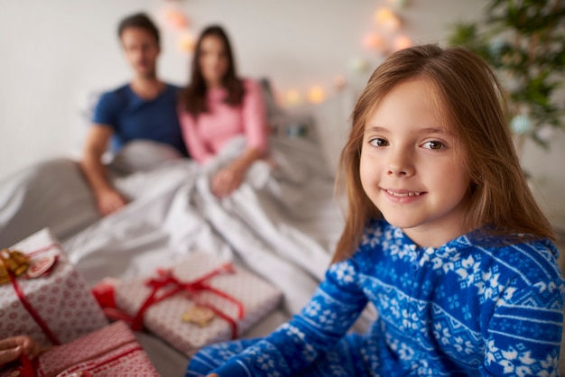 Niña esperando abrir regalos de Navidad