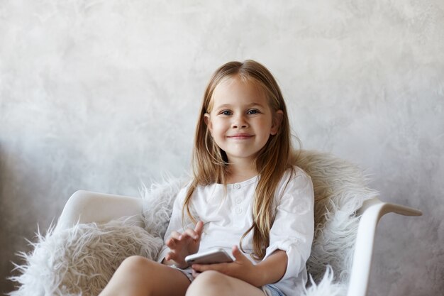 La niña está sentada en la sala