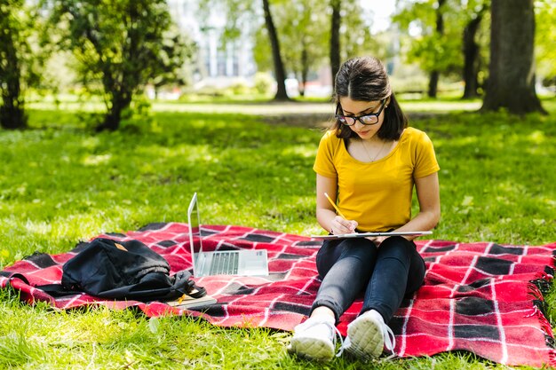 Niña estudiando concentrada en el parque