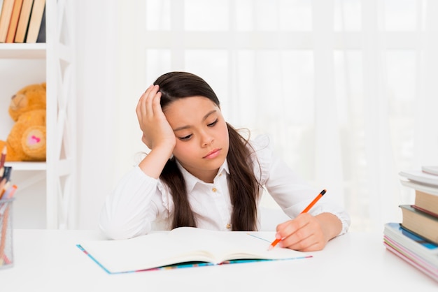 Niña étnica estudiando en casa