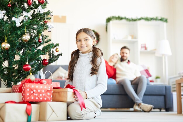 Niña feliz abriendo regalos de Navidad