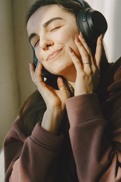 Niña feliz en auriculares escucha música en casa