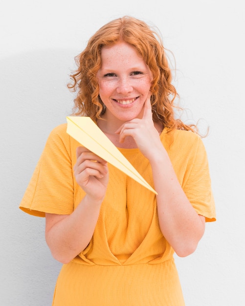 Foto gratuita niña feliz con avión de papel