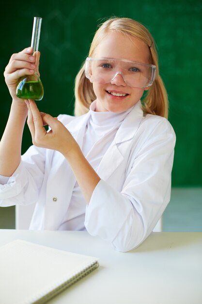 Niña feliz con bata blanca de laboratorio