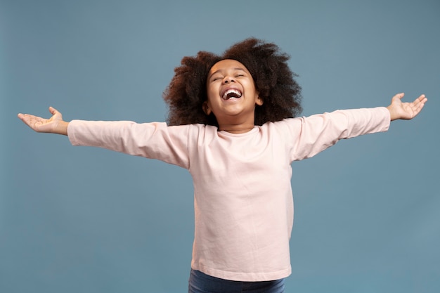 Foto gratuita niña feliz con cabello adorable sonriendo