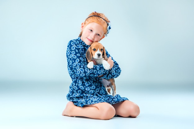 La niña feliz y un cachorro beagle