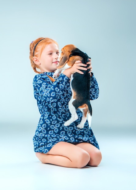 La niña feliz y un cachorro beagle