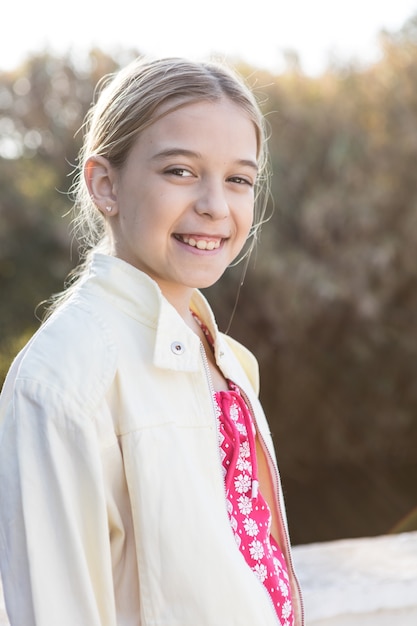 Foto gratuita niña feliz con chaqueta blanca