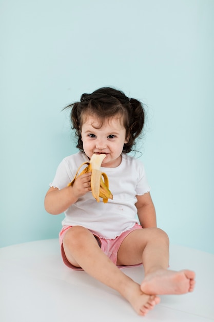 Niña feliz comiendo un plátano