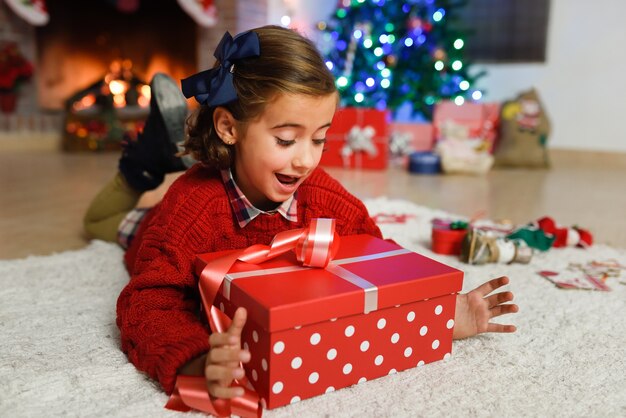 Niña feliz con decoración navideña y un regalo