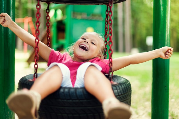 Foto gratuita niña feliz divirtiéndose en el patio de recreo