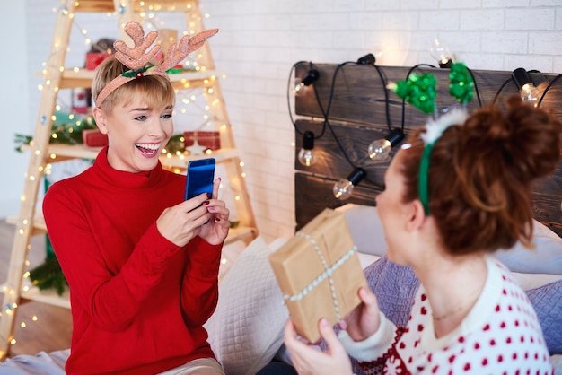 Niña feliz fotografiando regalos de navidad caseros