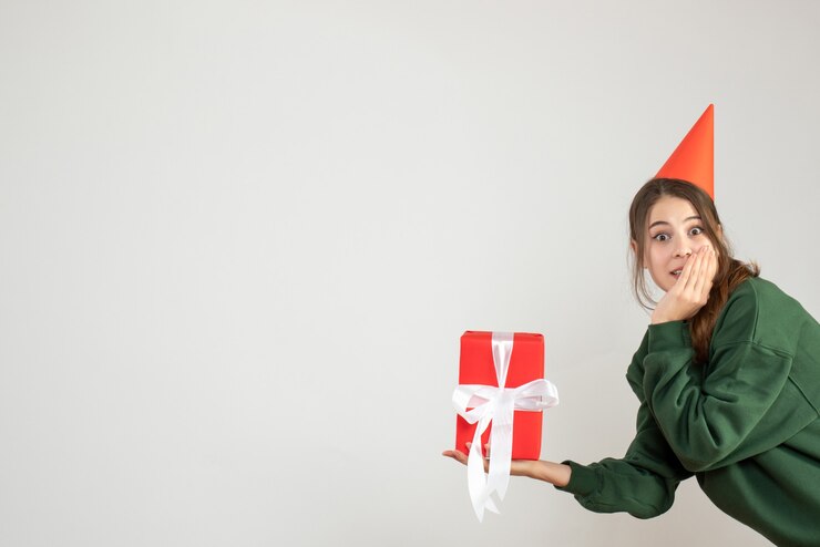 Foto gratuito niña feliz con gorro de fiesta con regalo en blanco