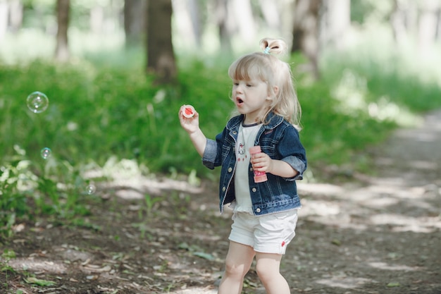 Niña feliz haciendo pompas de jabón