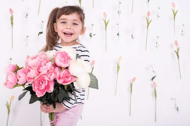 Niña feliz con hermoso ramo de rosas