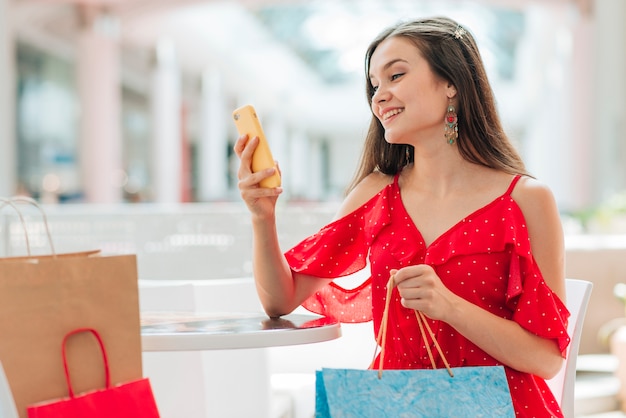 Foto gratuita niña feliz mirando su teléfono