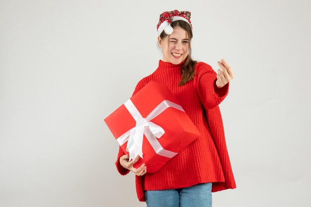 niña feliz con parpadeo de ojos sosteniendo regalo en blanco