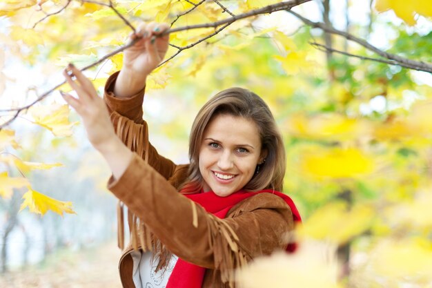 Niña feliz en el parque de otoño