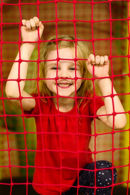 Niña feliz posando detrás de la red