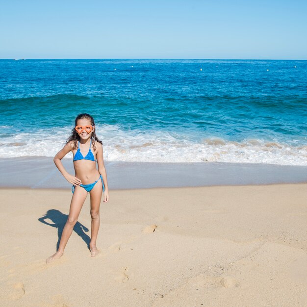 Niña feliz posando en la playa