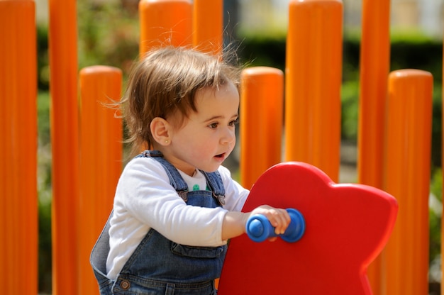 Niña feliz que juega en un patio urbano.