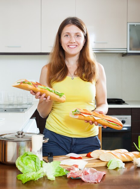 Foto gratuita niña feliz con sándwiches cocidos