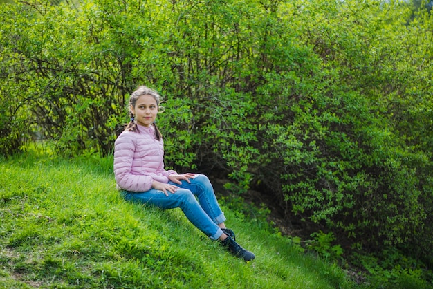 Niña feliz sentada en césped