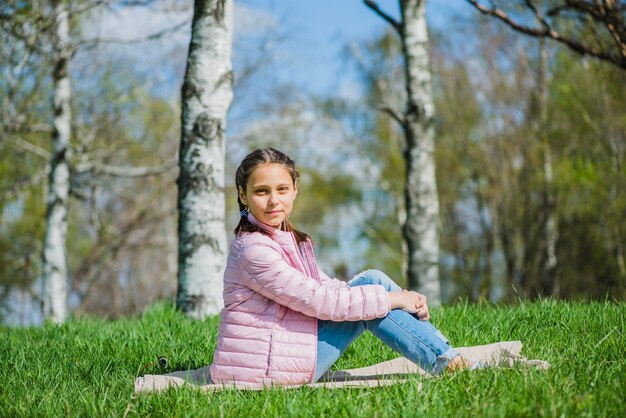 Niña feliz sentada en el parque