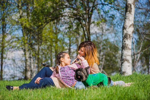 Foto gratuita niña feliz sentada con su madre en el parque