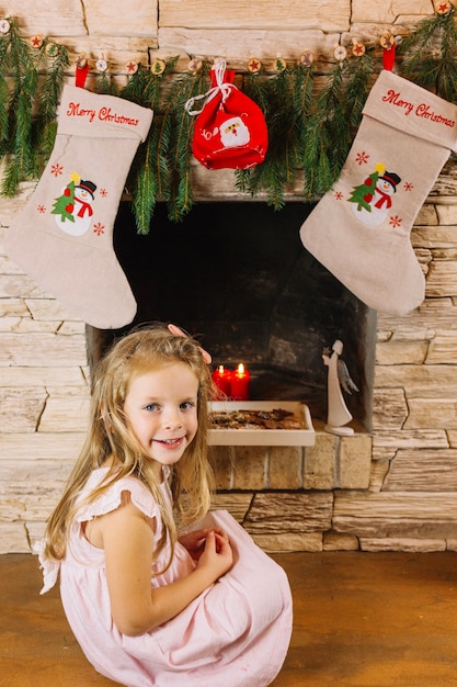 Foto gratuita niña en frente de chimenea