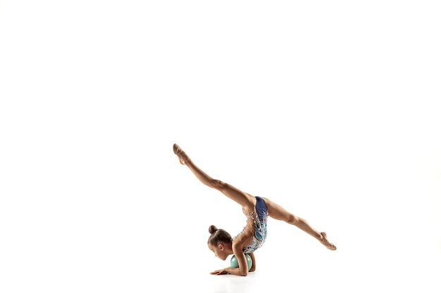 Niña gimnasta aislada en la pared blanca del estudio.