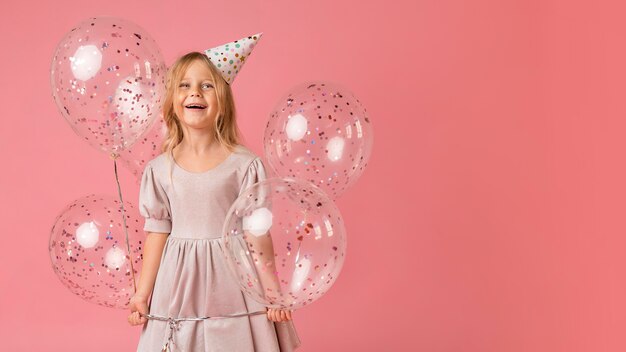 Niña con globos en traje y espacio de copia