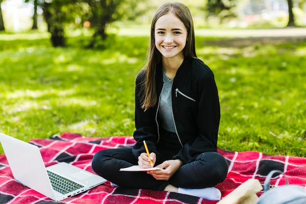 Niña guapa estudiando en el parque