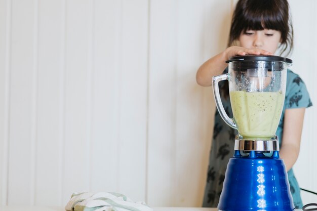 Niña haciendo batido con licuadora