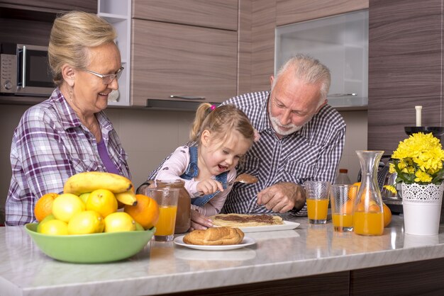 Niña haciendo panqueques con sus abuelos