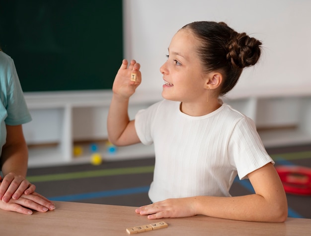 Niña haciendo terapia del habla en una clínica