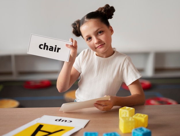 Foto gratuita niña haciendo terapia del habla en una clínica