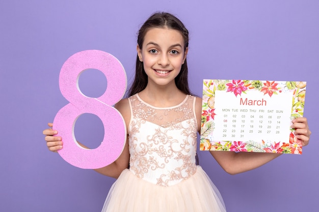 Foto gratuita niña hermosa sonriente en el día de la mujer feliz sosteniendo el número ocho con calendario