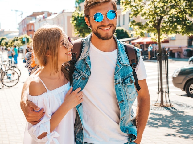 Niña hermosa sonriente y su novio guapo caminando en la calle.