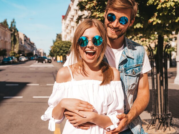 Niña hermosa sonriente y su novio guapo caminando en la calle.