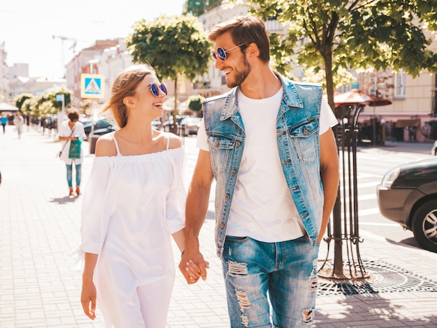 Niña hermosa sonriente y su novio guapo caminando en la calle.