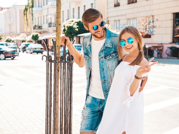 Niña hermosa sonriente y su novio guapo posando en la calle.