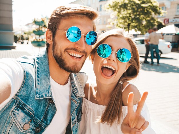 Niña hermosa sonriente y su novio guapo en ropa casual de verano.