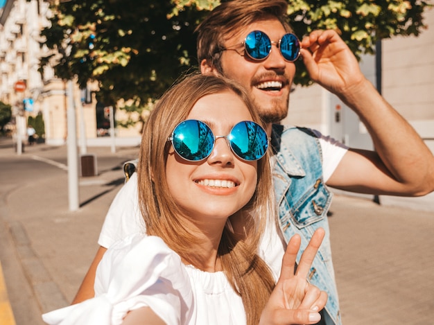 Niña hermosa sonriente y su novio guapo en ropa casual de verano.